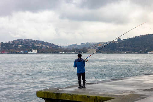 Istanbul, Turkey-March,09: People with fishing lines on Bebek Beach