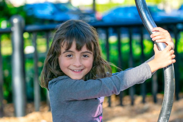Children, Portrait. Happy young girl playing with swing.