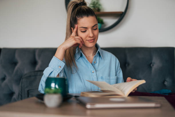 istock Young female reading book at cafe. 2078560829