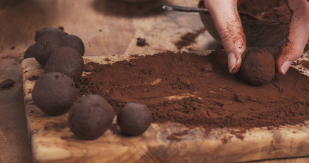 istock female hands making truffles in cocoa powder on board 2078603539