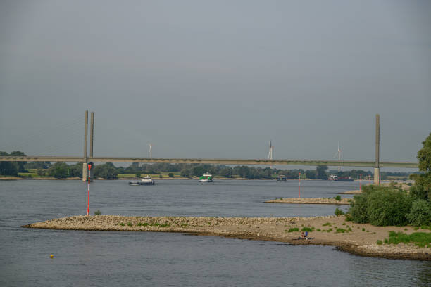 Cargo boats navigating the rhine river at dusk with cologne cityscape in the background