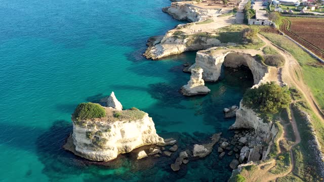 Stunning seascape with cliffs rocky arch and stacks (Faraglioni) at Torre Sant Andrea, Salento coast, Puglia region, Italy. Beautiful cliffs and sea stacks of Sant'Andrea, Salento, Apulia, Italy