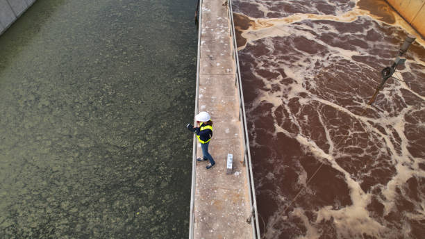 istock Drone view of Environmental Specialist walking through and  work inspecting water treatment pond 2078700654