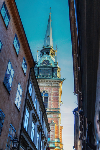 City narrow street with German Church, aka St Gertrude's Church, lies in the German quarter of Gamla Stan, Stockholm, Sweden.
