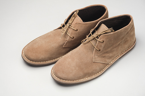 Suede desert boots on white background.