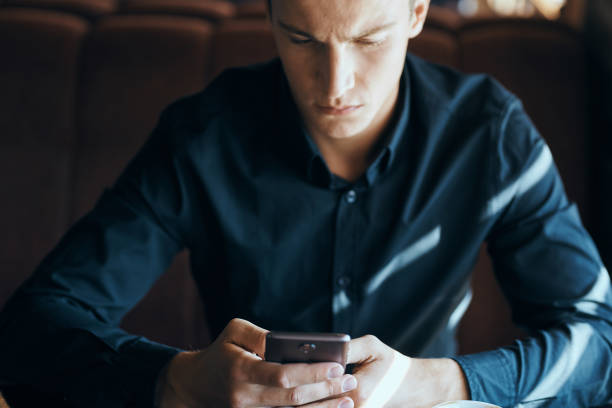 Businessman with mobile phone in cafe at table, cropped view. High quality photo