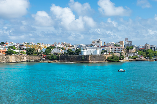 Travel image of old San Juan with city and historic walls along the waterfront , close at the port of San Juan, Puerto Rico.