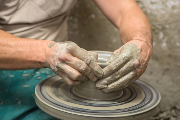 A potter makes a vase out of clay. Manufacture of pottery. A man's hands at work.