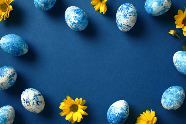istock Frame of blue and white Easter eggs and yellow flowers on dark blue background. Top view. Flat lay. 2078823060