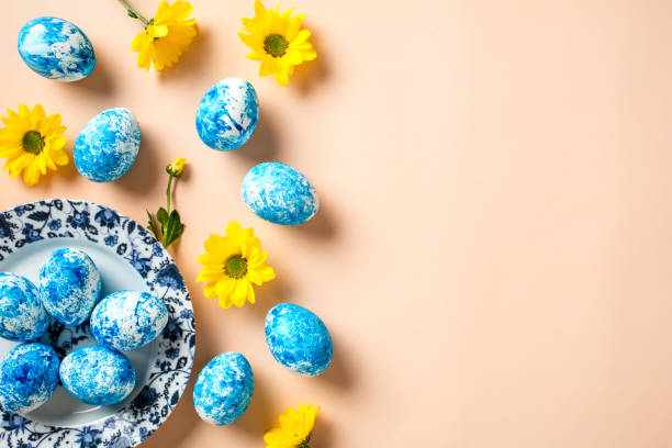 istock Plate with blue and white Easter eggs and yellow flowers on beige background. Happy Easter concept. 2078826650
