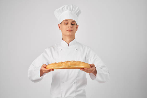 a man in chef's clothes Holding a loaf baker Professional. High quality photo