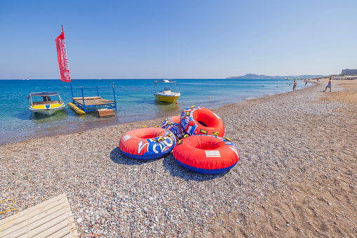 Rhodes, Greece. 09.20.2023. View of red inflatable rings, inviting enthusiasts for an exhilarating ride towed by a motorboat.