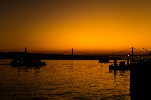 25th April Bridge in Lisbon, Portugal at dawn right after sunset. Famous landmark on river Tagus.