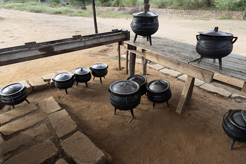 meals cooked on the side of the road by an african street vendor in few large pots