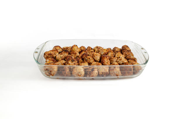 brown oven air fried meatballs in a glass tray, isolated on white - garlic roasted brown studio shot imagens e fotografias de stock