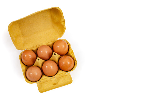 6 eggs yellow carton pack, flat lay isolated on white background, with negative space