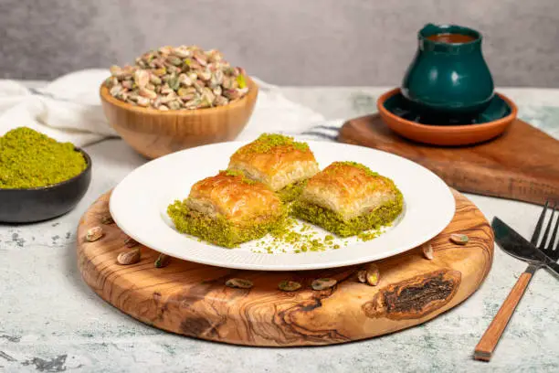 Photo of Baklava with pistachios on a wooden background. Turkish cuisine delicacies. Ramadan Dessert. local name kuru baklava