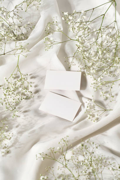 istock Small greeting cards on a table with silk white cloth and flowers 2078886134