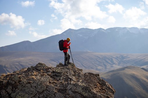 The tourist hiking the mountain trail at sunrise