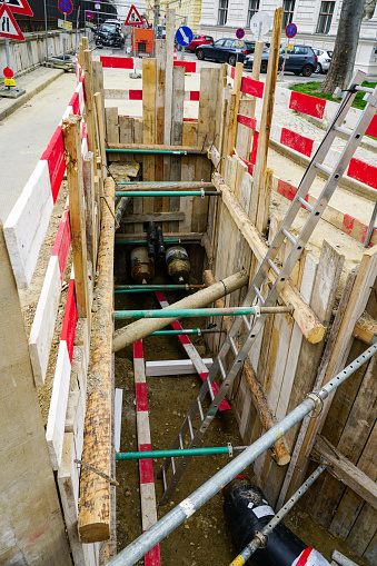 Replacement of underground heating pipes in a city street, deep trench with sliding equipment to support the ground