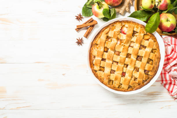 istock Apple pie with ginger and cinnamon at white wooden table. 2078921925