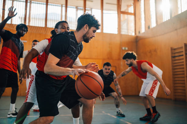 istock Basketball player is dribbling ball and playing on training with his team 2078924544