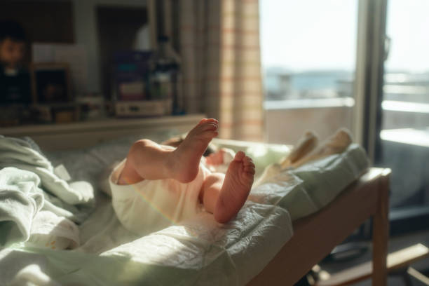 a newborn baby lying on  bed in the sun