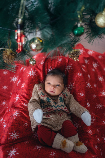 a newborn baby in a christmas sweater