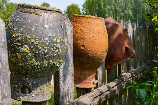 Clay brown jugs on a rural wooden fence, Poland, Podlasie