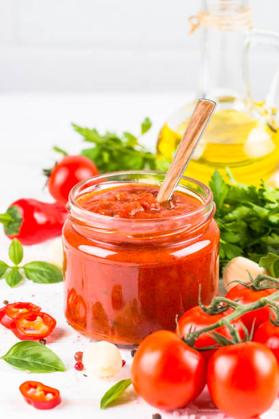 istock Tomato sauce with herbs and spices at white background. 2078946265