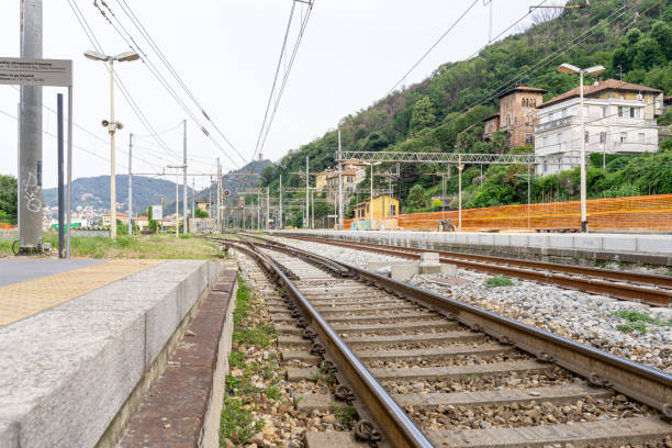 At the foot of the railroad tracks is the bustling train station in Como, Italy. The perspective from this point is one of anticipation and movement. The rhythmic clatter of departing trains echoes in the air, mingling with the voices of passengers and the clink of luggage carts. Beyond the platform, the city of Como bustles with activity, its streets alive with the energy of everyday life. From this vantage point, one witnesses the convergence of journeys - some begin, some end.
