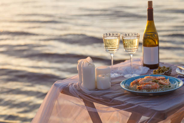 istock Romantic sunset dinner on the beach. Table honeymoon set for two with luxurious food, glasses of champagne drinks in a restaurant with sea view. Summer love, romance date on vacation concept. 2078975246