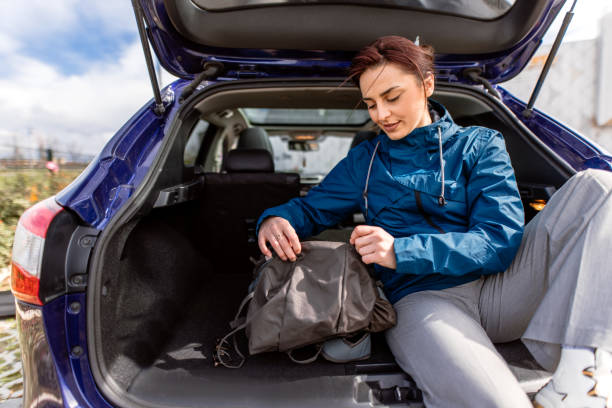 istock Woman packing backpack in car trunk 2078980553