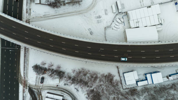drohnenfotografie von mehrspurigen straßen in einer stadt während eines wintertages - driving industry land vehicle multiple lane highway stock-fotos und bilder