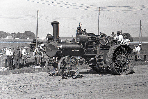 Cedar Falls, Iowa, USA - August 23, 1958: Case steam traction engine with saw attachment in the Threshermen's Field Days parade. The large steam engine like this would have been used to power a threshing machine or other farm machinery. Although steam engines and steam tractors were used in the US until the late 1930s and early 40s, collector groups were already forming by the time this photo was taken in 1958 to preserve steam engines and tractors.
