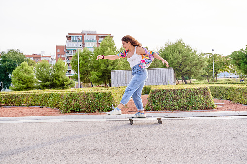 woman riding skateboard in rush concept. break the rules. Active young lady riding skateboard in city