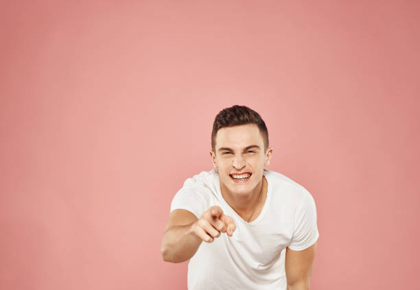 istock A man gestures with his hands in a white t-shirt emotions pink background 2079033054