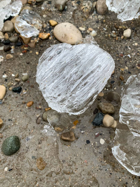istock Chunks of ice on sandy beach with small pebbles 2079033613
