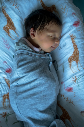 a newborn baby sleeping  swaddle