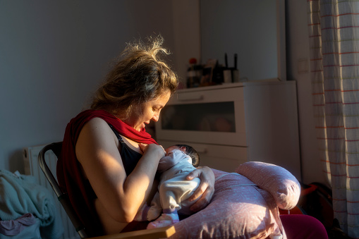 a woman breastfeeding her baby in a domestic home
