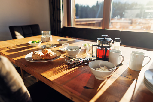 Table prepared for breakfast - buns, cheese, tea and vegetables, Sunny morning. 
Shot with Canon R5