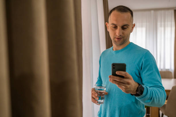 istock Business person dressed in casual clothes  checking mail box  on the smart phone while resting of the work with glass of water. 2079086554