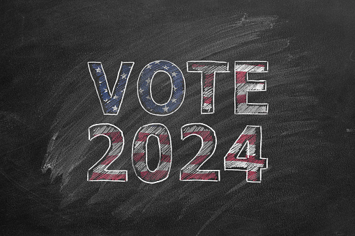 The inscription VOTE 2024 In the colors of the American flag is drawn with chalk on a blackboard. US Presidential election 2024. Election Day in United States