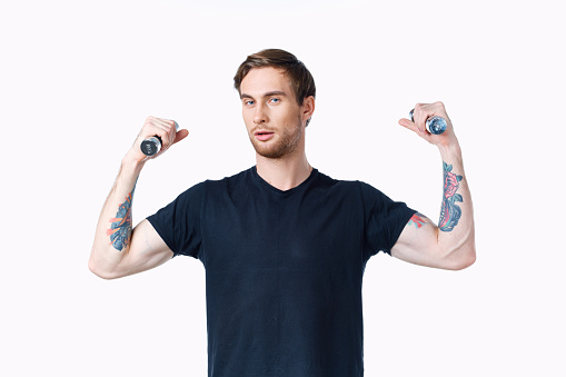 man with pumped up muscles of arms and dumbbells black t-shirt white background. High quality photo