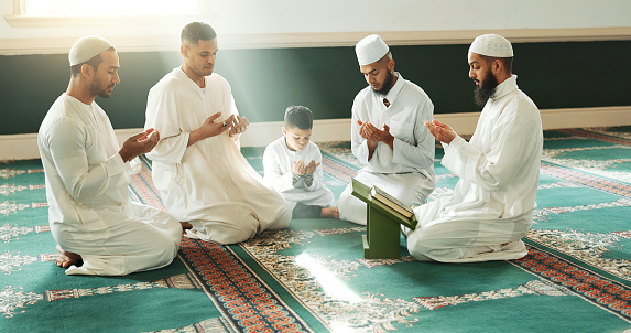 Muslim, praying and men with child in Mosque for spiritual religion together as family to worship Allah in Ramadan. Islamic, Arabic and holy people with peace or respect for gratitude, trust and hope