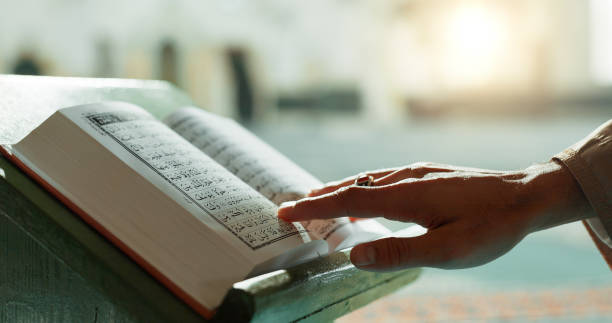 Hands, Quran and closeup of woman reading in mosque for religion study, faith or worship. Gratitude, praise and zoom of muslim female person with holy book for spiritual wellness in islamic temple. manos, corán y primer plano de una mujer leyendo en la mezquita para el estudio de la religión, la fe o el culto. gratitud, alabanza y zoom de la persona femenina musulmana con el libro sagrado para el bienestar espiritual en el templo islámico.