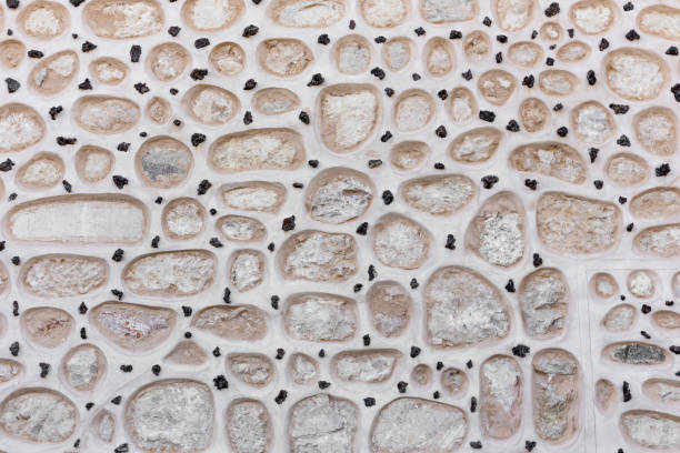Stone facade with round stones built in the wall with small black stones in between, Spain.
