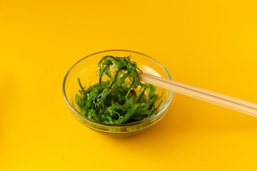 chuka salad in a glass plate with chopsticks