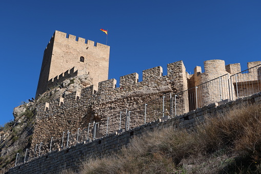 Sax, Alicante, Spain, March 12, 2024: Wall and tower of the Almohad castle of Sax on top of a rock. Sax, Alicante, Spain