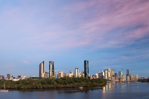 Sunrise view over the Brisbane River and Brisbane city with the new pedestrian bridges. Beautiful pre-sunrise light on the city buildings and pink clouds in the sky as seen from Kangaroo Point Cliffs.
